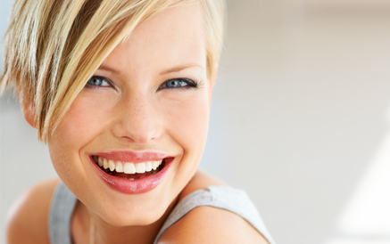 A woman smiles after a facial rejuvenation procedure
